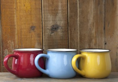 Ahşap arka planda üç renkli kahve fincanı.