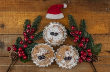 Noel kekleri pudra şekeri ve Noel süsüsüyle süslenmiş ahşap masa. Üst görünüm