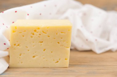 Ahşap masada bir kalıp peynir.