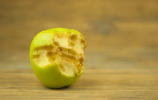 被咬的老苹果在木头背景上拍照 — 图库照片