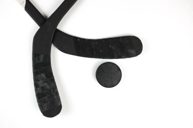 A fragment of a hockey stick and puck on a white background clipart
