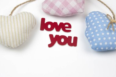 Sevgililer günü kartı. Beyaz kağıt arka planda el yapımı kumaştan kalpler olan hoş bir kompozisyon. Doğum günün kutlu olsun ya da yıldönümün kutlu olsun. Kopyalama alanı olan romantik ileti şablonu.