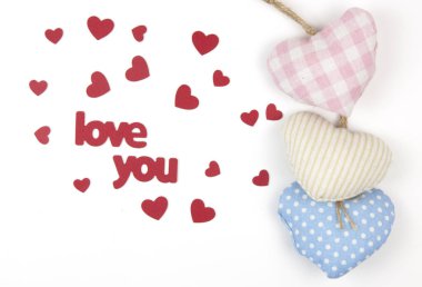 Sevgililer günü kartı. Beyaz kağıt arka planda el yapımı kumaştan kalpler olan hoş bir kompozisyon. Doğum günün kutlu olsun ya da yıldönümün kutlu olsun. Kopyalama alanı olan romantik ileti şablonu.