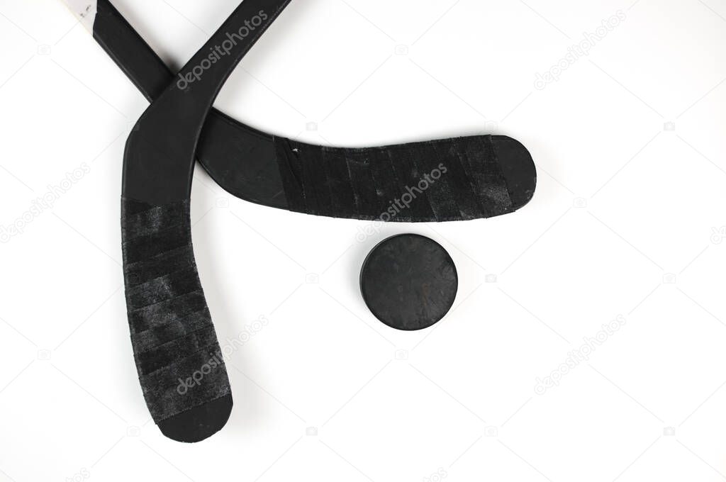 A fragment of a hockey stick and puck on a white background