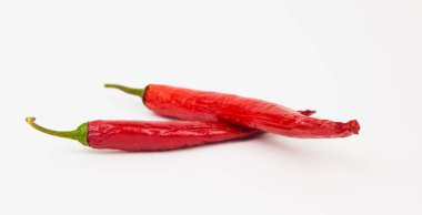 Beyaz arka planda duran iki kırmızı biber. Biber pişmeye hazır..