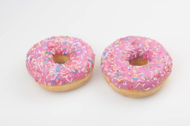 Beyaz arka planda iki pembe çörek.