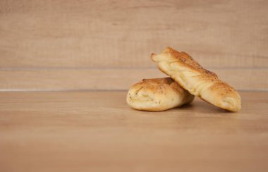 Ahşap masada haşhaş tohumlu iki çörek.