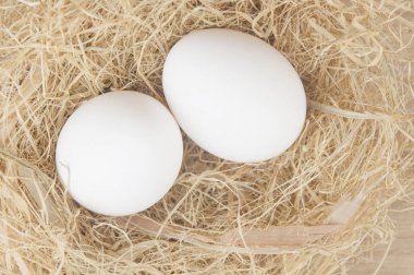 Mutfak masasında Paskalya için saman bulunan sepetteki tavuk yumurtaları. Metin ve başlığı yapıştırmak için yer