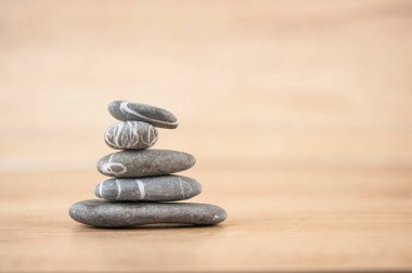 Tahta bir yüzeyde çakıl taşı yığını. Zen, spa, rahatla.