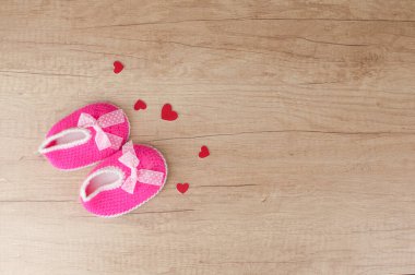 Bebek ayakkabısı ya da bebek ayağı ve kırmızı kalpler fotokopi masasının üstünde. Üst görünüm