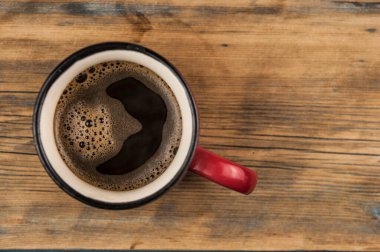 Fotokopi alanı olan ahşap arka plandaki kahve fincanının üst görüntüsü.
