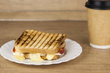 Jambonlu, peynirli, domatesli ve kızarmış ekmekli büyük bir sandviç.