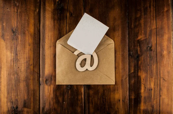 在一个老式木制桌子上有一个写着白色空白纸的电子邮件标识 概念电子邮件消息信 带有复制空间的顶部视图 — 图库照片