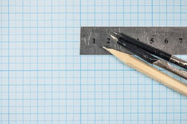 Kendi tasarımınızı eklemek için kalem, pusula ve metal cetvelli mühendislik grafiklerinin fotoğrafı.