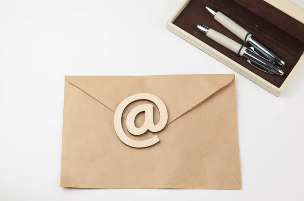 ペンと木のサインの入った封筒電子メールは白い背景にあります コンセプトメールメッセージレター トップ表示 — ストック写真
