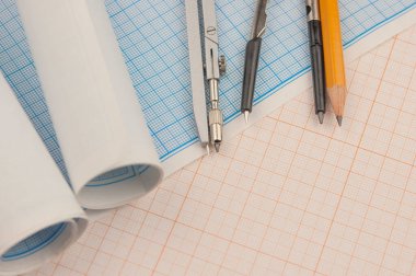 Matematiksel enstrümanlar metin için fotokopi alanı olan bir grafik kağıdının üzerinde yatar. Matematik grafik araçları kavramı.