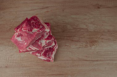 Ahşap bir masada büyük bir parça çiğ domuz boynu. Yakın plan, kopyalama alanı