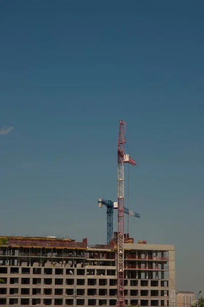 建設現場だ 未完成の高層ビルや背景に青空と大きな産業タワークレーン スキャフォールド 現代の土木工学 現代都市景観 — ストック写真
