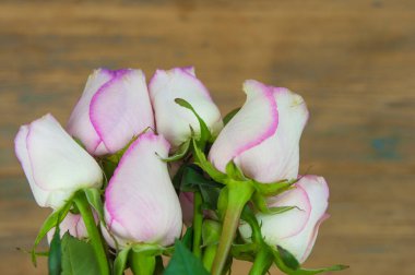Ahşap arka planda pembe güller. Anneler günü gülleri, pembe gül buketi, metin için fotokopi alanı olan çiçek arkaplan resmi