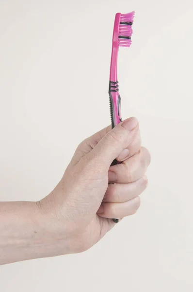 白い背景に歯ブラシを持っている女性の手 — ストック写真