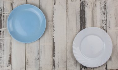 Kırsal beyaz ahşap bir masada boş bir seramik tabağın üst görüntüsü