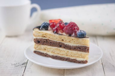 Böğürtlenli pastayı beyaz tabakta ahşap arka planda karıştır