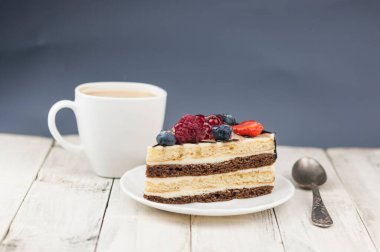 Böğürtlenli pastayı beyaz tabakta ahşap arka planda karıştır