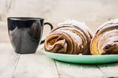 Beyaz ahşap masada iki taze kruvasan. Kahvaltı.