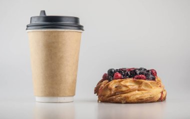 Beyaz arka planda kağıt tek kullanımlık kahve fincanı olan lezzetli meyveli börekler. Kahvaltı.