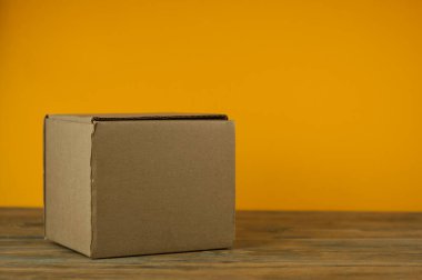 Paket kutusu ahşap masada, renkli arkaplanda.