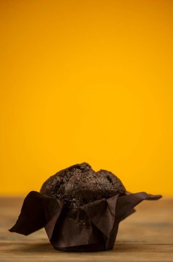 Tahta bir masanın üzerine, toz şeker serpiştirilmiş ev yapımı çikolatalı kekler.