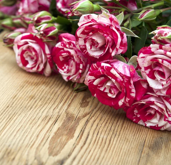 Ramo de rosas sobre mesa de madera — Foto de Stock