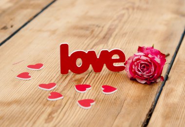 üzerinde kırmızı-beyaz gül ve dağınık çiçek yaprakları ve kelime aşk 