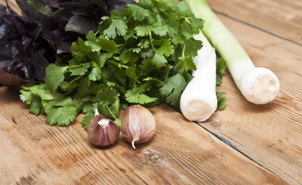 Fondo di cibo sul tavolo di legno: prezzemolo, basilico, aglio e le — Foto Stock