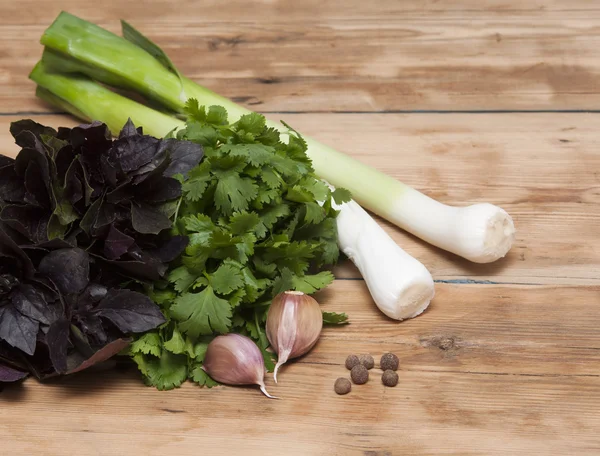 Fondo alimentare sul tavolo di legno: prezzemolo, basilico, aglio, pepe — Foto Stock