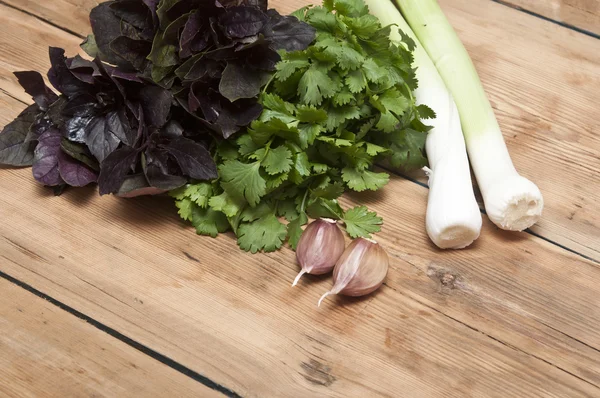 Fondo di cibo sul tavolo di legno: prezzemolo, basilico, aglio e le — Foto Stock