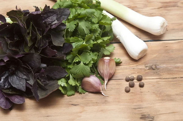 Fondo alimentare sul tavolo di legno: prezzemolo, basilico, aglio, pepe — Foto Stock