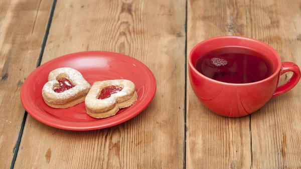 Cup of tea and homemade cookies in the shape of a heart — Stock Photo, Image