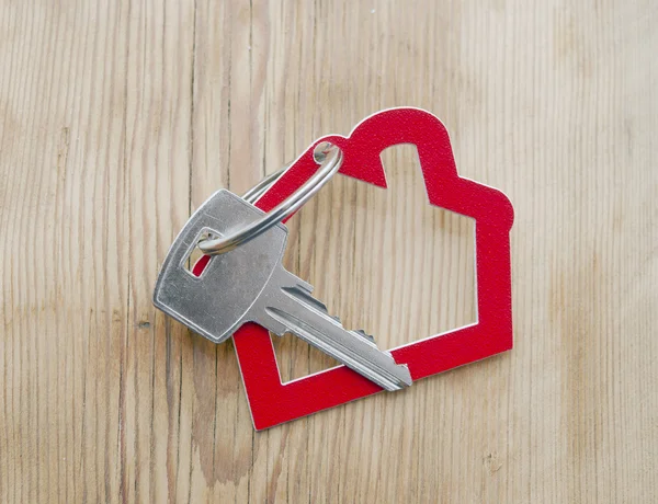 Symbole de la maison avec clé argent sur fond bois vintage — Photo