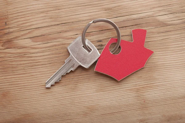 Símbolo de la casa con llave de plata sobre fondo de madera vintage —  Fotos de Stock