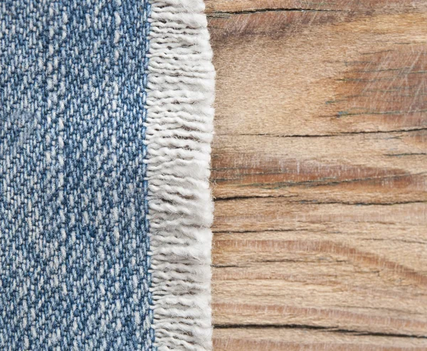 Текстура синего джинса на фоне текстуры дерева — стоковое фото