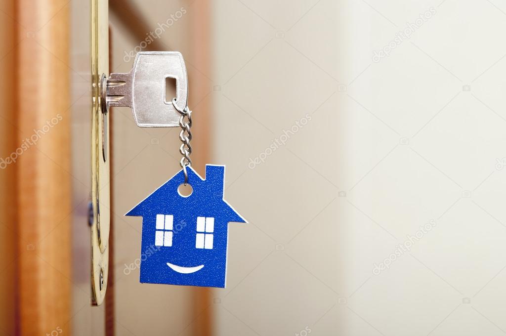 A key in a lock with house icon with smile on it