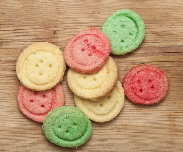 Biscoitos de açúcar multicoloridos em fundo de madeira — Fotografia de Stock