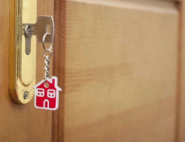 Symbol domu a držet klíč v klíčové dírky — Stock fotografie