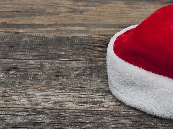 Kerstmuts op houten tafel met kopieerruimte — Stockfoto