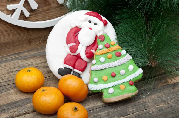 Gingerbread cookie with mandarins on an old wooden Christmas bac — Stock Photo, Image