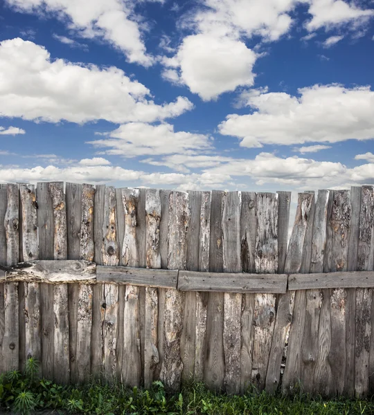 Ancienne clôture en bois contre le ciel bleu avec des nuages — Photo