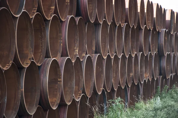 Close-up de uma pilha de tubos de aço grandes e enferrujados — Fotografia de Stock