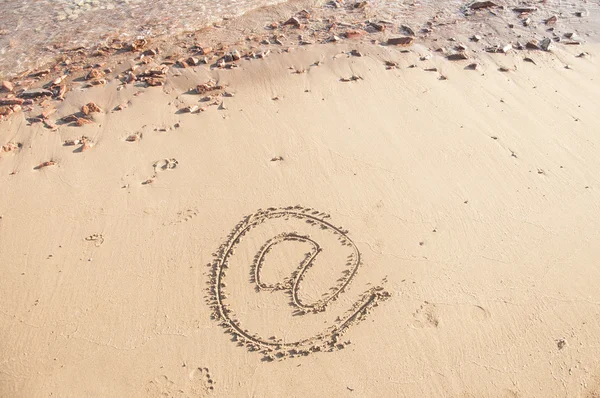 E-mail teken geschreven in het zand op een strand. — Stockfoto