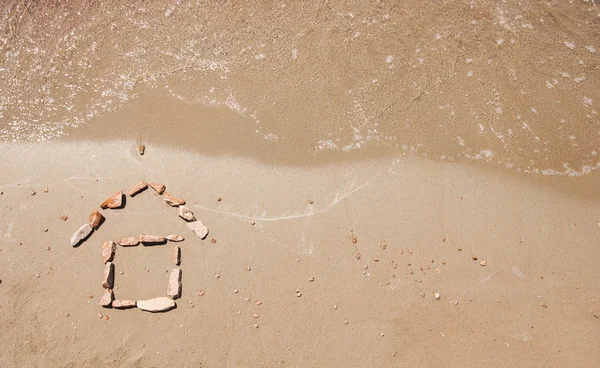 Pequeña casa dibujada en la arena de la playa de mar —  Fotos de Stock